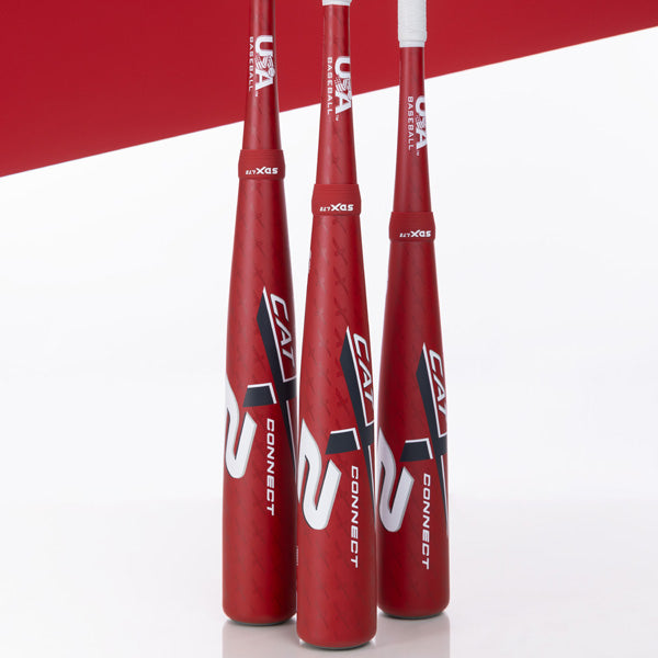 Three red baseball bats with white and black CAT 5 CONNECT branding stand upright side by side against a white and red background. The words USA Baseball are also visible near the handles.