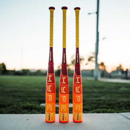 Several baseball bats, including the 2025 Easton Hype Fire (-5) 2 3/4" USSSA Baseball Bat (EUT5HYP5 DEMO) by Easton, are lying on a concrete surface.
