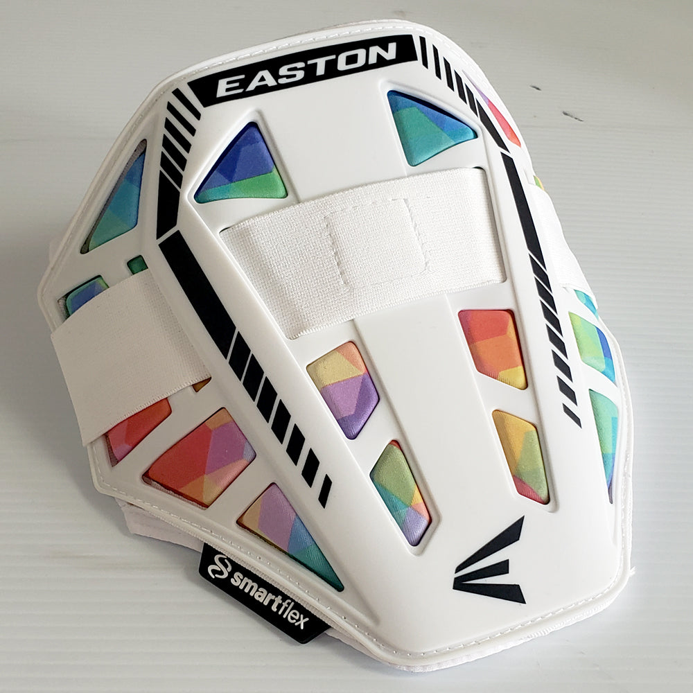 The Easton Compact Batter Elbow Guard: ES37 is a white Easton elbow guard with black accents, vibrant geometric rainbow patterns, and a white adjustable center strap. The SmartFlex logo appears near the bottom edge for added style and protection.