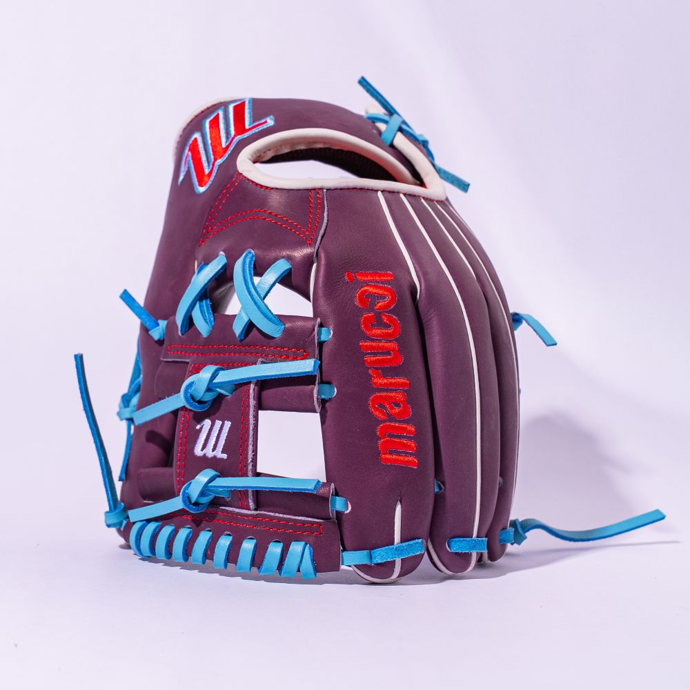 The Marucci NightShift Jetski 11.5" Baseball Glove (MFGNTSHFT-0403), made from Japanese-tanned steerhide with blue laces and white accents, is shown upright against a light purple background with "marucci" embroidered in red.