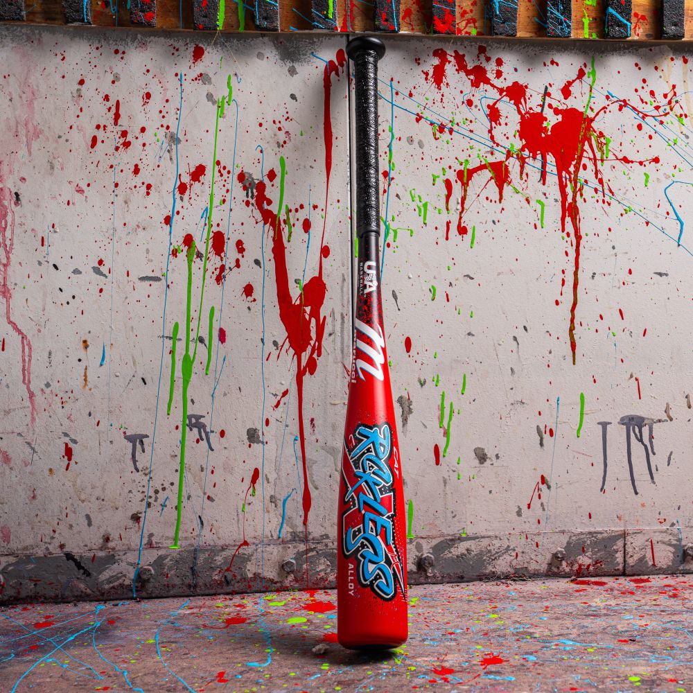 A 2026 Marucci CAT X RCKLESS (-8) 2 5/8" USA Baseball Bat (MSBCR8USA) by Marucci stands in front of a wall with vibrant paint splatters.