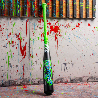 The 2026 Marucci CAT X RCKLESS Hybrid (-5) 2 3/4" USSSA Baseball Bat stands upright, featuring a neon green grip and graffiti-style lettering, with vibrant red, green, and blue paint splatters in the background.