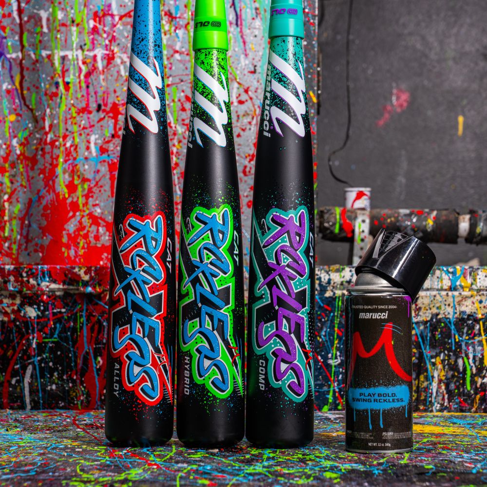 Three vibrant Marucci CAT X RCKLESS (-8) 2 3/4" USSSA Baseball Bats (MSBCR8) stand upright beside a black spray paint can, set against a splattered, paint-covered backdrop.