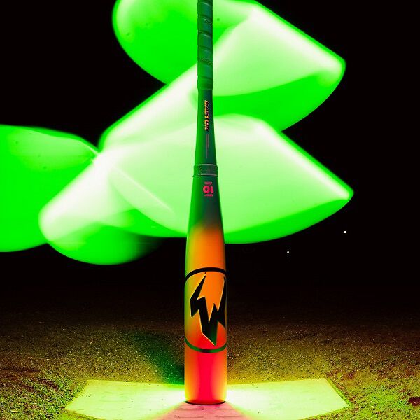 The 2026 Easton Hype Fire (-11) 2 5/8" USA Baseball Bat (EUS6HYP11) by Easton stands upright on home plate, its lightning bolt logo glowing under dramatic green light trails at night.