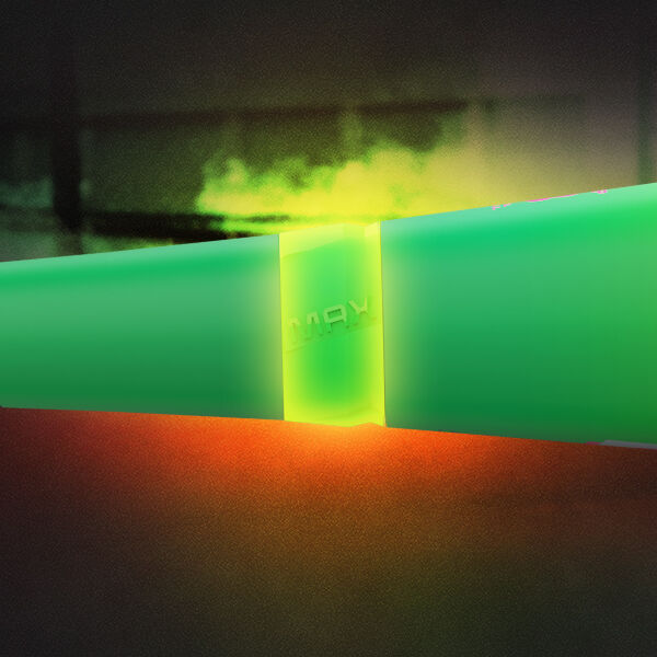 A glowing green rectangular object with a bright yellow light at its center is set against a dark background with hints of red and green lighting.