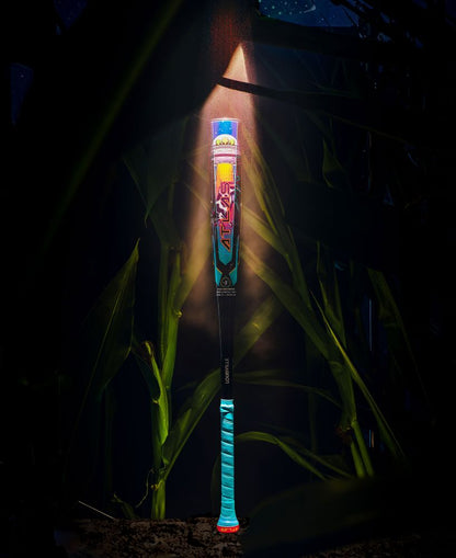 The 2026 Louisville Slugger Atlas A51 (-3) BBCOR Baseball Bat (WBL4180010) stands upright, bathed in light with blue and red accents, surrounded by tall green corn stalks at night.