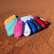 Eight vibrant baseball gloves line up on the orange dirt of a field with a white home plate behind them—perfect companions for your EvoShield Shorty Sliding Mitt 2.0 (WB57728) by EvoShield.