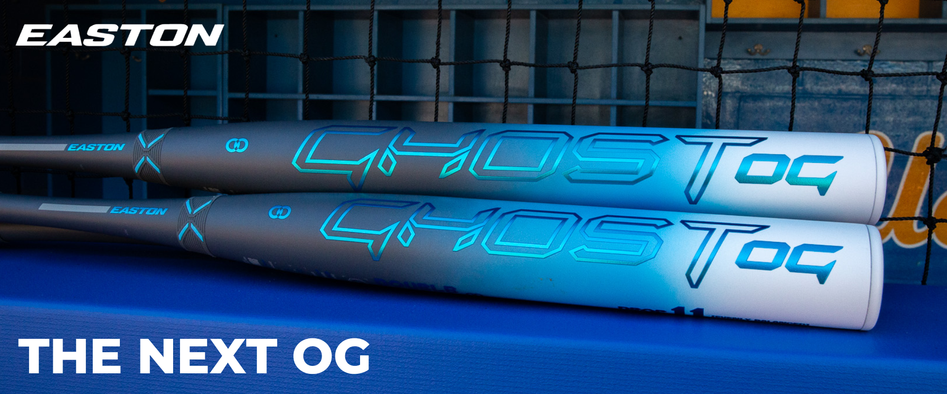 Two easton ghost og fastpitch softball bats laying in a dugout with promotional text