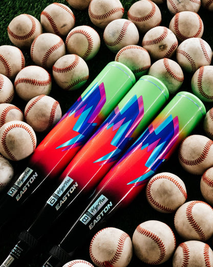 Three vibrant baseball bats, including the 2027 Easton Hype Fire (-10) 2 3/4″ USSSA Baseball Bat (EUT7HYP10) by Easton—featuring a TCT Barrel and ConneXion Max technology—display striking green, blue, and red designs as they rest on grass among scattered white baseballs with red stitching.