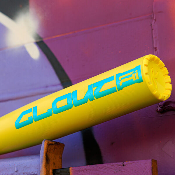 A yellow 2026 Rawlings Clout AI (-3) BBCOR Baseball Bat (RBB6C3) with “GLOUCE” in blue letters leans against a purple wall covered in graffiti.