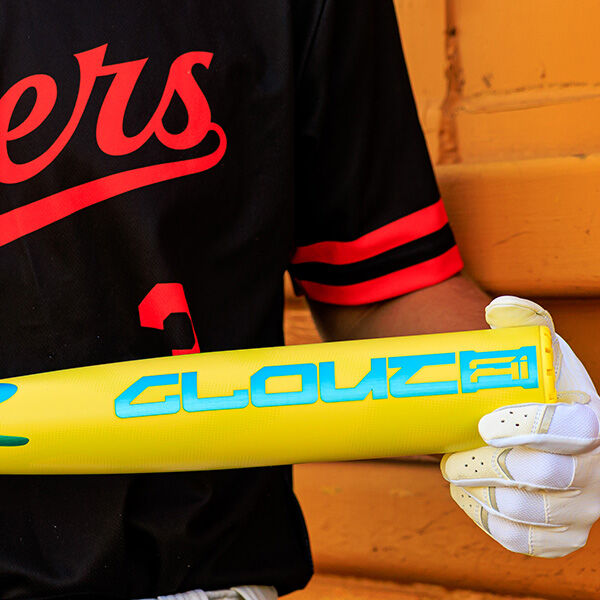 A person in a black and red jersey with white gloves holds a yellow 2026 Rawlings Clout AI (-3) BBCOR Baseball Bat (RBB6C3) featuring blue "GLOUCE" lettering.