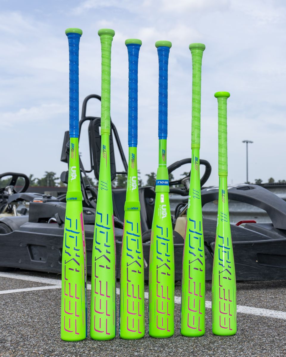 Six lime green Marucci Rckless USA baseball bats with blue or green grips stand upright in a row, each featuring a composite barrel designed for maximum barrel flex, set against a background with a black go-kart on asphalt.