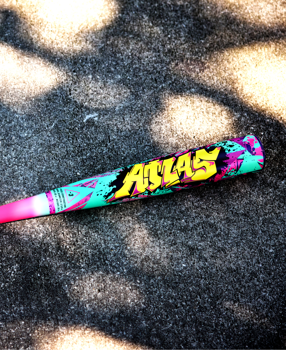 The 2026 Louisville Slugger Atlas Wildstyle (-3) BBCOR Baseball Bat (WBL4178010) features bold yellow graffiti-style text and vibrant pink, teal, black, and purple designs, making it a colorful 1-piece alloy bat from Louisville Slugger.
