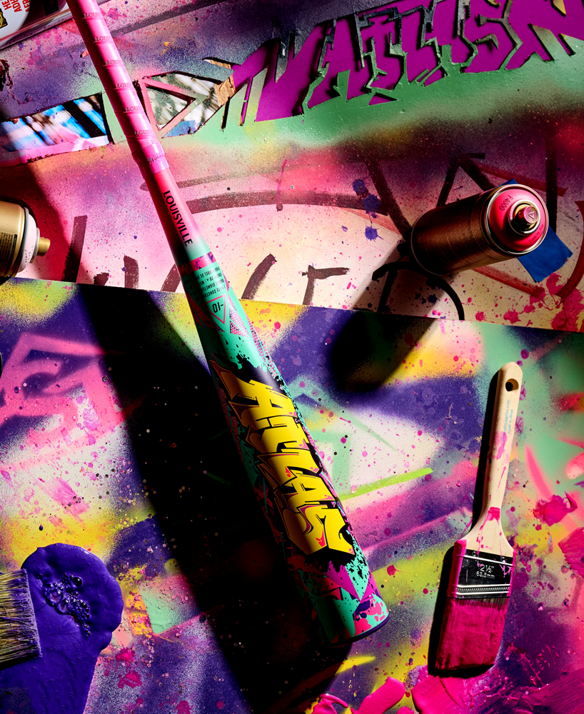 Atlas bbcor baseball bat surrounded by Graffiti-style paint can with a brush on a colorful, abstract background