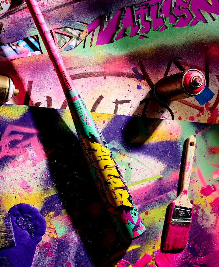Atlas bbcor baseball bat surrounded by Graffiti-style paint can with a brush on a colorful, abstract background