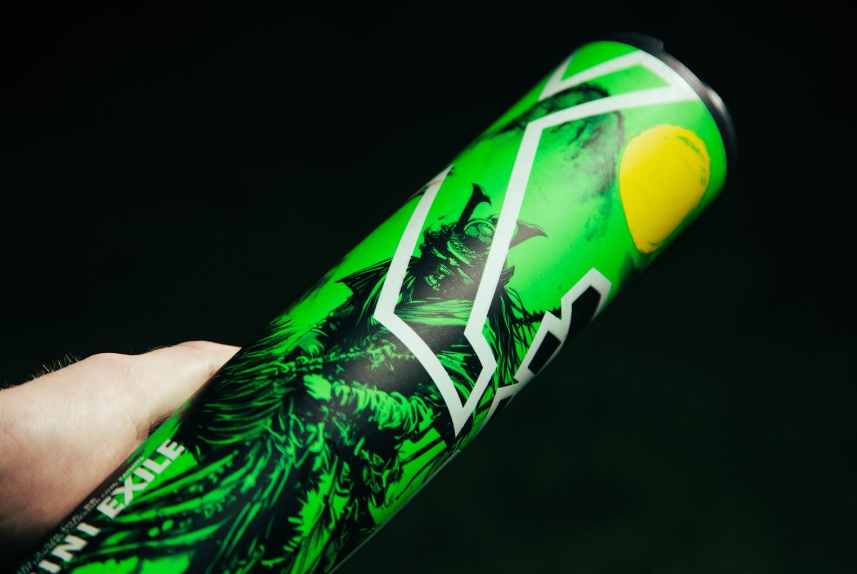 A hand holds a bright green tennis ball can with bold graphics—much like the eye-catching design of the 2026 DeMarini Exile Samurai (-3) BBCOR Baseball Bat: WBD2652010 by DeMarini.