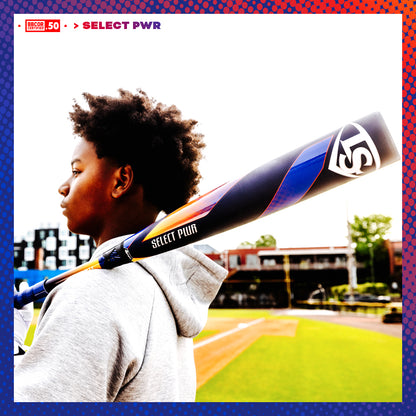 A young baseball player stands on a field with the 2025 Louisville Slugger Select PWR (-3) BBCOR Baseball Bat (WBL2967010 DEMO) resting on his shoulder, gazing into the distance with stadium seating and buildings behind him under a bright sky.