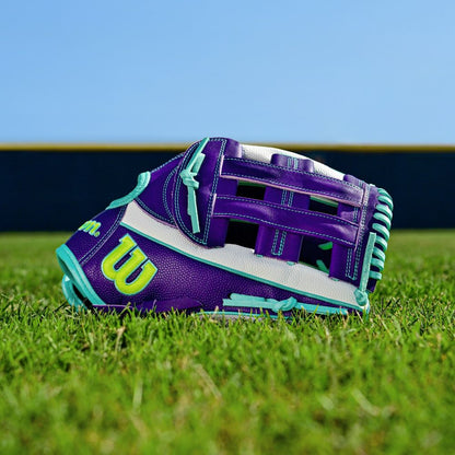 The Wilson A2000 FP50SS 12.25" Fastpitch Glove (FALL 2025) features a purple, teal, and white Pro Stock leather design with a yellow W logo, shown on green grass under a blue sky with a blurred fence in the background.