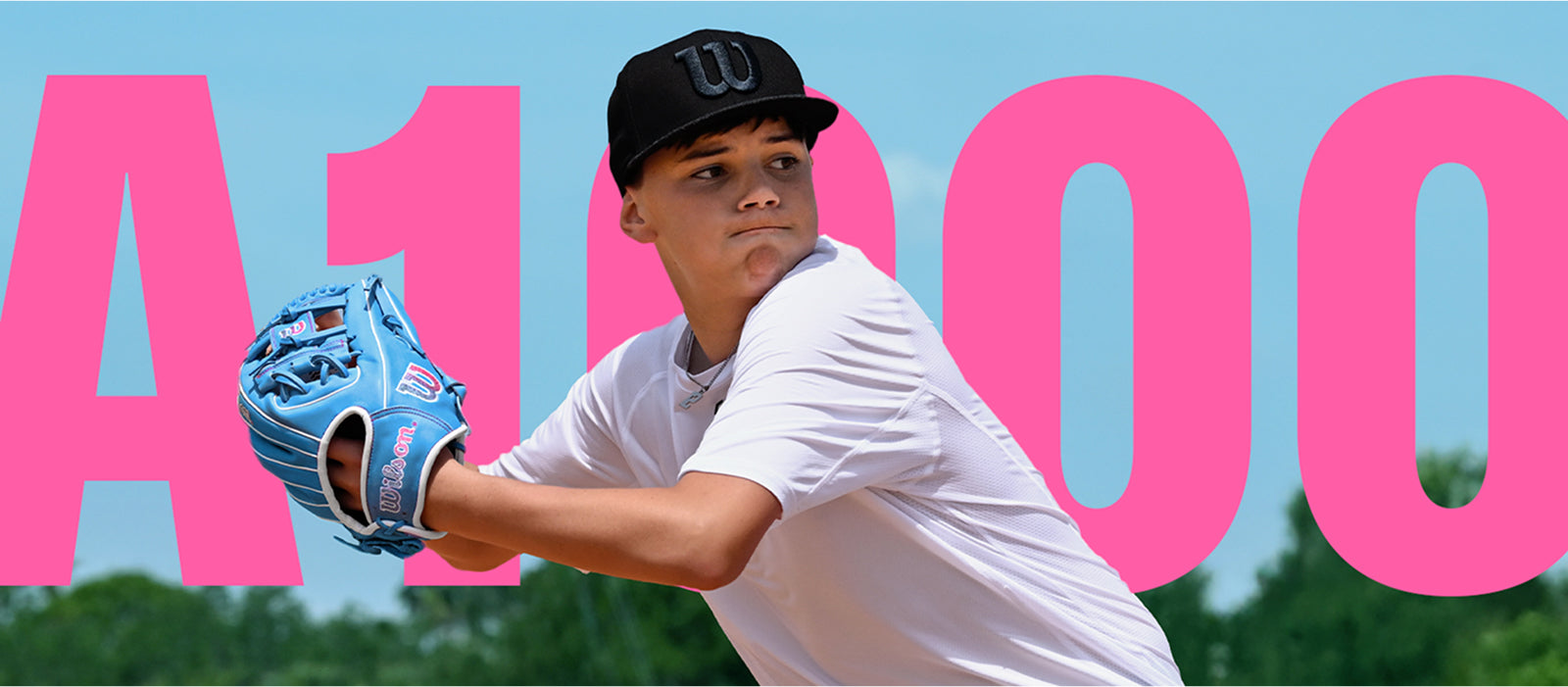 A young baseball player in a white shirt and black cap winds up to pitch, wearing a blue glove. Large pink letters and numbers A1000 are in the background against a blue sky.