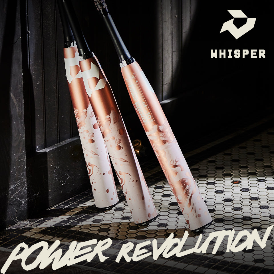 Three stylish baseball bats with white and rose gold swirling designs stand upright on a tiled floor near a dark wooden doorway. The Whisper brand logo and POWER REVOLUTION text are prominently displayed.