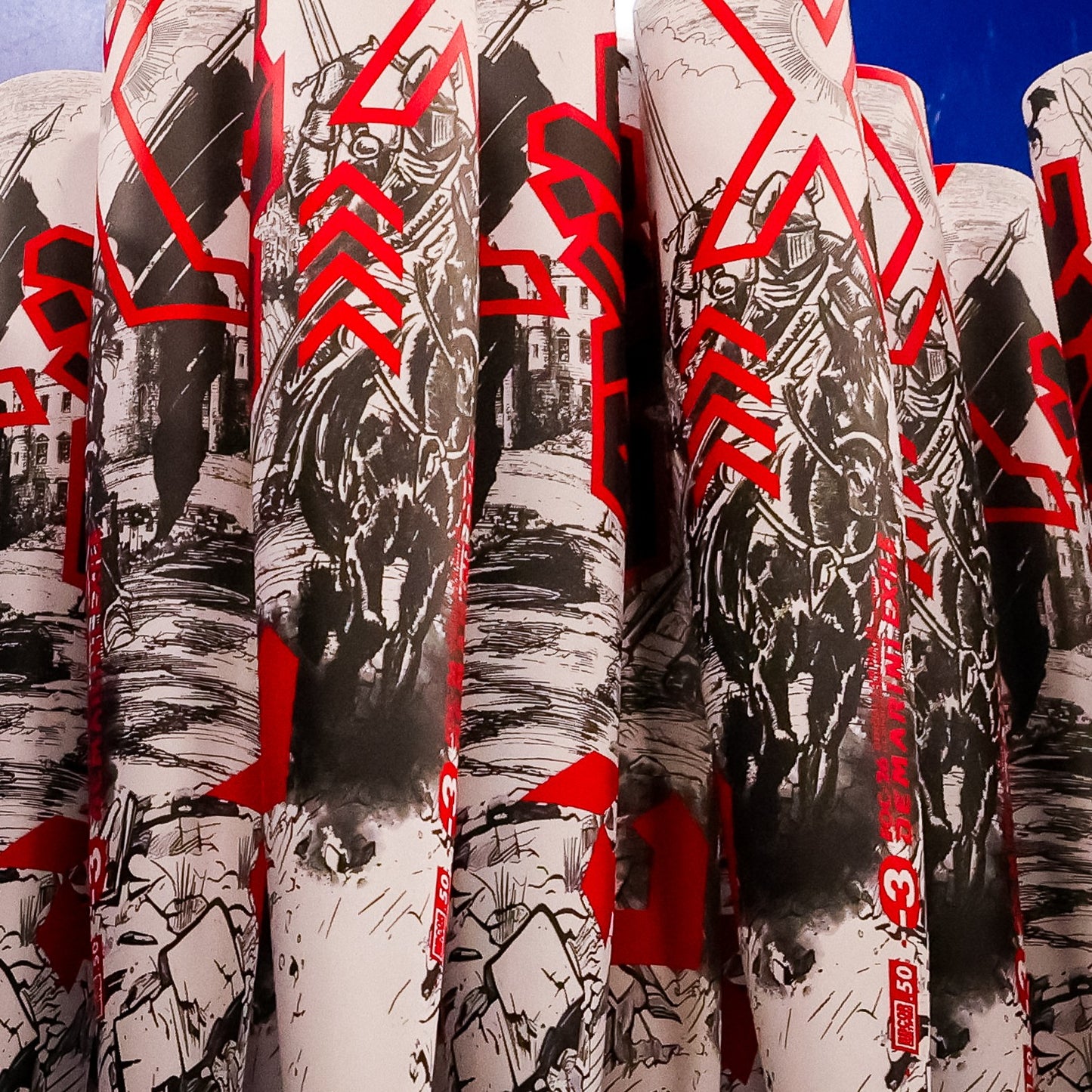 Several cylindrical objects are stacked vertically, each featuring black and white illustrations of armored knights on horseback, accented with bold red patterns and numbers inspired by the 2026 DeMarini Exile (-3) BBCOR Baseball Bat: WBD2589010 by DeMarini.