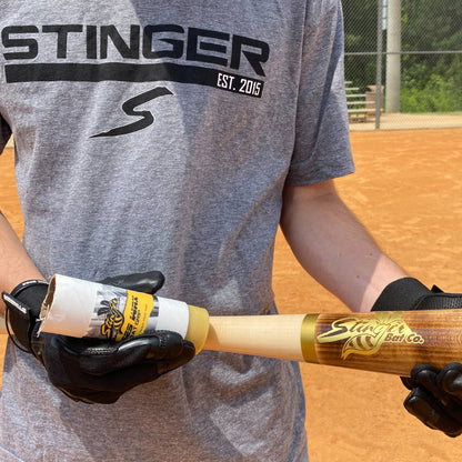A person holding a baseball bat with a Stinger Sports Stinger BEES WAX Bat Grip: BEESWAX.