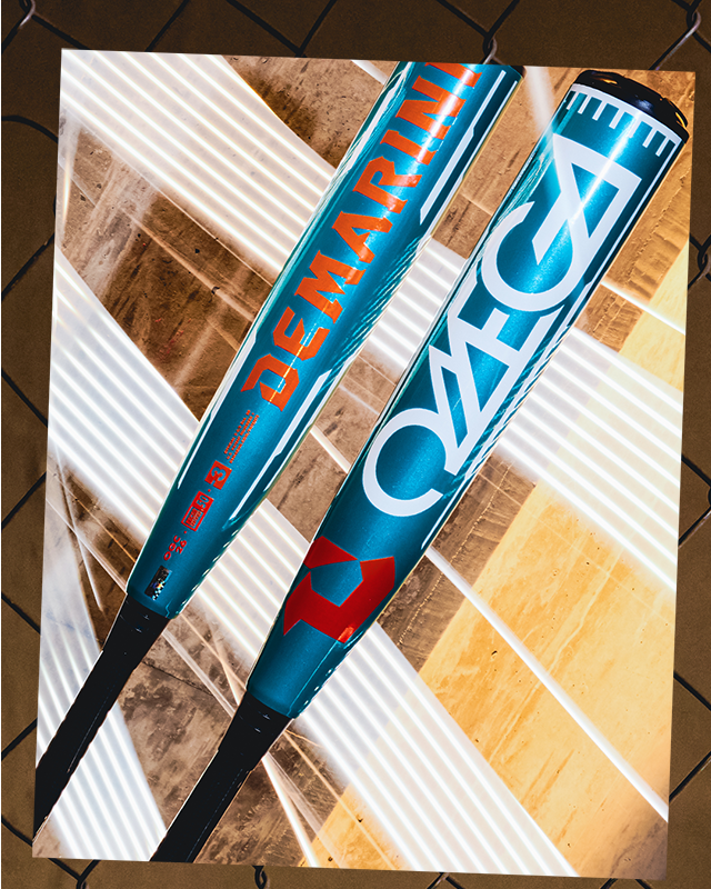 Two blue 2026 DeMarini Omega (-3) BBCOR Baseball Bats (WBD2586010) with orange and white DeMarini branding, featuring the X14 Alloy Barrel, are displayed against a vibrant backdrop framed by a chain-link fence.