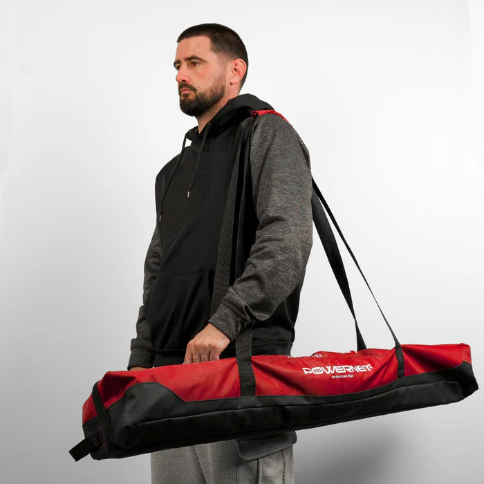 A man holds the PowerNet 7' x 7' Deluxe Replacement Carry Bag, ideal for carrying your PowerNet hitting net.