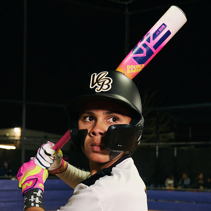 A young player in a black helmet and pink gloves grips an Easton 2026 Dub (-10) 2 3/4" USSSA Baseball Bat (EUT6DUB10) with two-piece composite construction, preparing to swing under stadium lights.