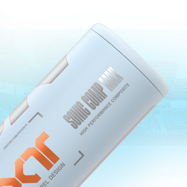 Close-up of a silver and white baseball bat labeled SONIC COMP MAX HIGH PERFORMANCE COMPOSITE with orange and gray text, set against a light blue, blurred stadium background.