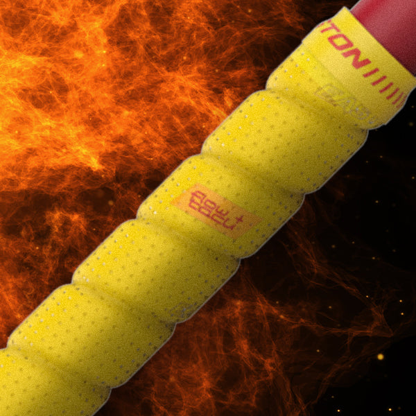 Close-up of a yellow, textured racket grip with red text, set against a dynamic orange and black fiery background.