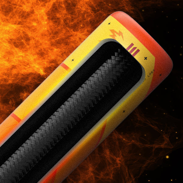 A close-up of a futuristic, yellow and orange object with a textured black strip, set against a fiery, flame-filled background. The object has symbols and patterns, suggesting advanced technology or a sci-fi theme.
