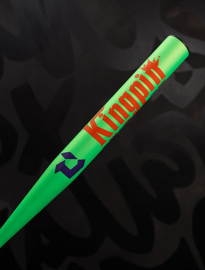 A neon green 2027 DeMarini Kingpin 13.5" Midload SSUSA Senior Slowpitch Softball Bat (WBD2693010) with bold orange "Kingpin" and a yellow crown above the i, set against a dark, blurred background.