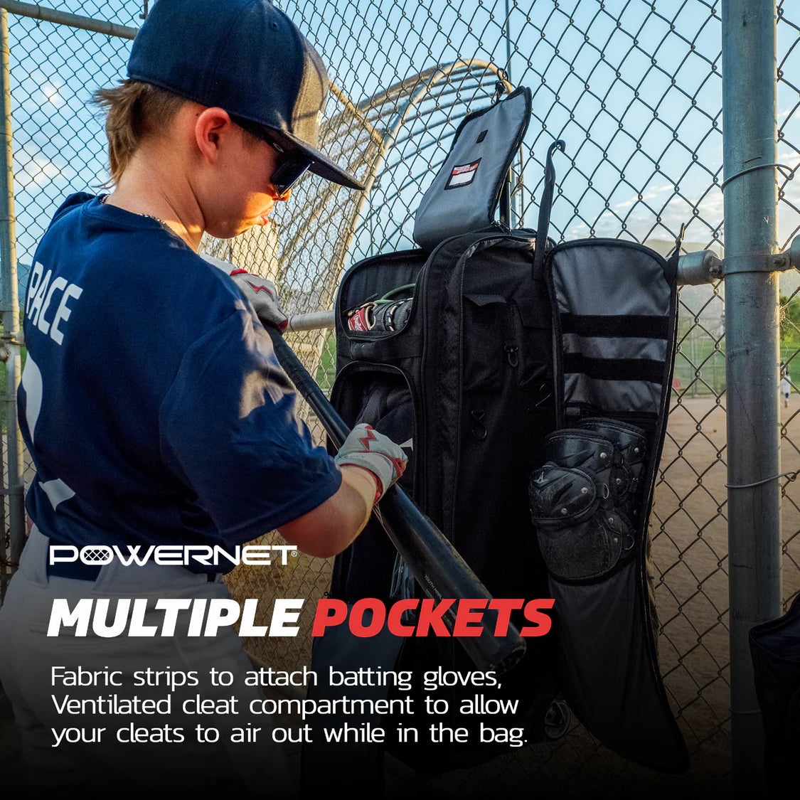 A young baseball player in blue puts on batting gloves next to a PowerNet Optimus Catcher's Gear Bag (B013-BK) with multiple compartments and ventilation, hanging from a fence. Text highlights the bag's pockets and airflow features.