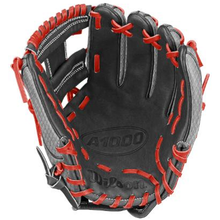 A black Wilson A1000 DP15 FIREBIRD 11.5″ Baseball Glove (WBG24601RT115) with red laces, open and ready to catch a ball, features the Wilson Pro Stock branding on the palm and incorporates Pedroia Fit technology for a snug, comfortable feel.