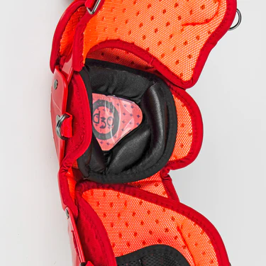 Close-up of the interior padding and protective structure of a red and orange sports elbow pad, showing breathable mesh fabric and cushioned support with a visible D3O label.