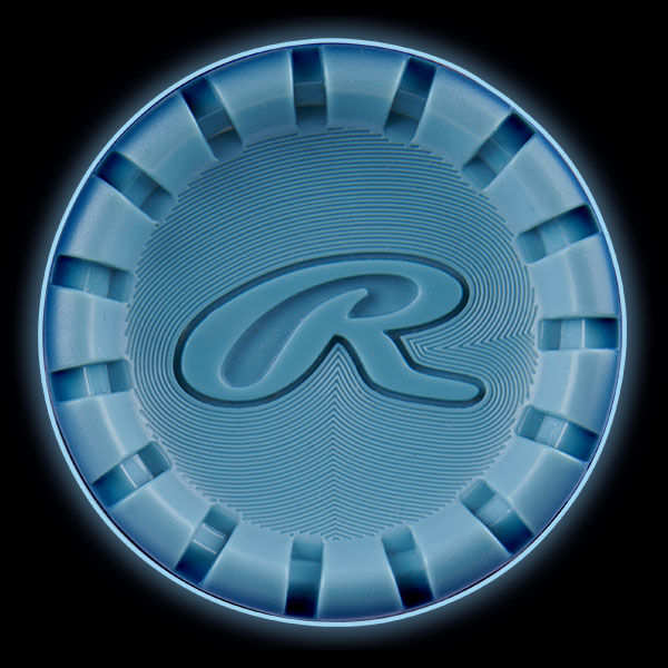 A blue poker chip with ridged edges and a stylized letter R embossed in the center, viewed from above against a black background.