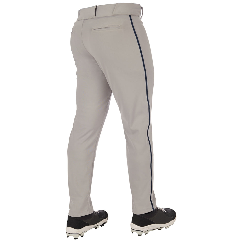 A person faces away, wearing Champro Sports Adult Triple Crown 2.0 Tapered Baseball Pants with piping (BP66) in light gray, featuring a dark side stripe and paired with black cleats with white soles.