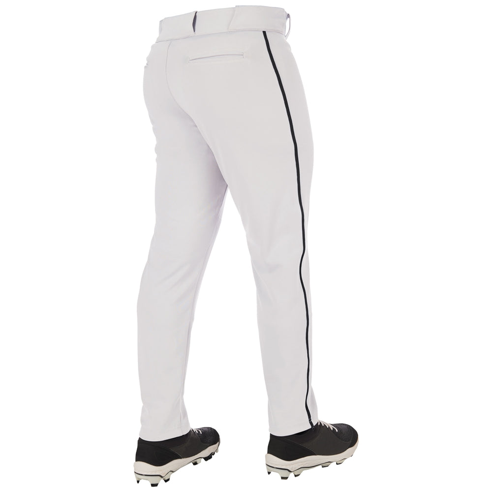 A person stands with their back to a white background, wearing Champro Sports Adult Triple Crown 2.0 Tapered Baseball Pants with black piping (BP66) and black cleats. These pants feature durable pro-weight fabric and a tapered fit.
