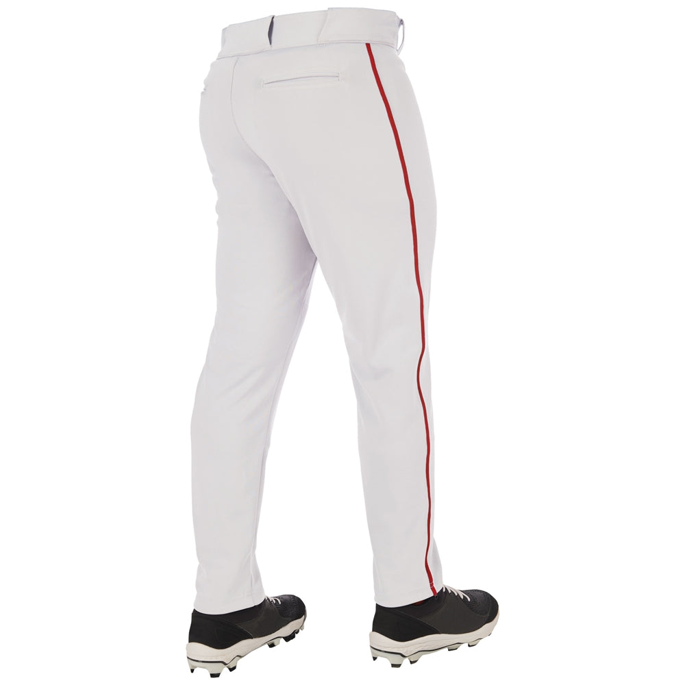 Someone stands with their back to the camera, wearing Champro Sports Adult Triple Crown 2.0 Tapered Baseball Pants with red piping (BP66), made from pro-weight fabric, along with black cleats.