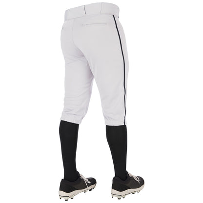 A person wearing Champro Sports Youth Triple Crown 2.0 Knicker Baseball Pants with Piping (BP70Y), black knee-high socks, and black cleats stands with their back to the camera.