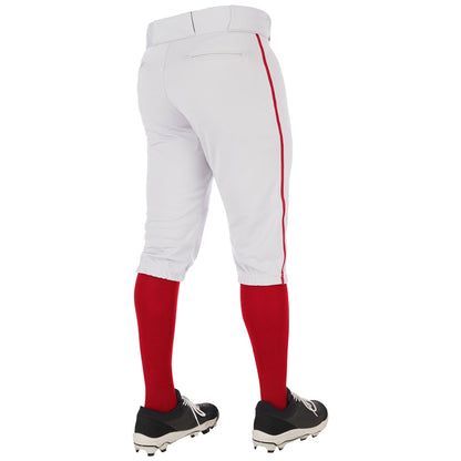 A person is shown from the back, standing on a white background, wearing Champro Sports Youth Triple Crown 2.0 Knicker Baseball Pants with red piping (BP70Y), red socks, and black cleats.