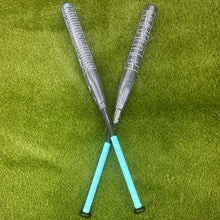 A pair of composite bats, including the Pure Sports 2025 Storm Shadow 13″ Balanced USA Slowpitch Softball Bat (5147M91B), rests on the grass.