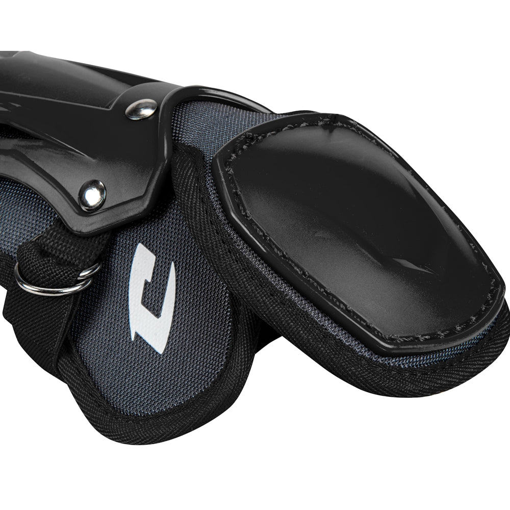 A close-up of Champro Optimus Pro Catcher's Leg Guards (CG18) by Champro Sports showing black and gray protective gear with hard plastic outer shells, a PE shin plate, and fabric straps for athletic leg protection.
