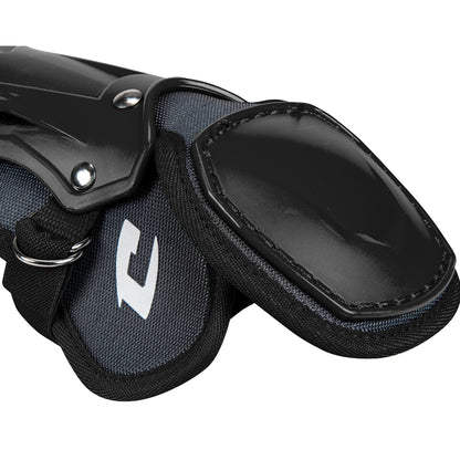 A close-up of Champro Optimus Pro Catcher's Leg Guards (CG18) by Champro Sports showing black and gray protective gear with hard plastic outer shells, a PE shin plate, and fabric straps for athletic leg protection.