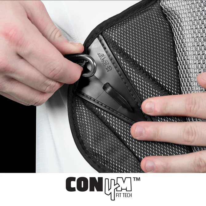 Close-up of hands adjusting a black strap on the All Star MVP Pro Catcher's Chest Protector: CPCC-5, featuring mesh-textured support and built to SEI Certified NOCSAE standard. "CON4M FIT TECH" text appears at the bottom.