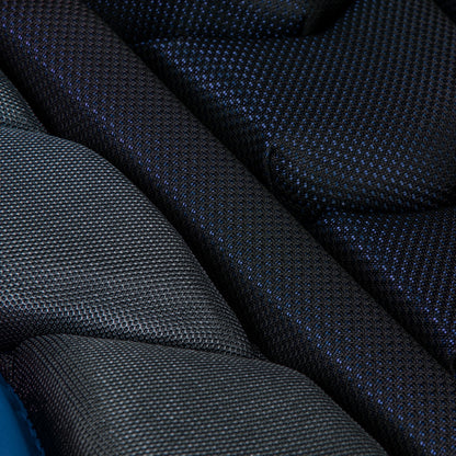 Close-up of textured, padded black and dark gray fabric with a blue tint, layered to resemble the Champro Sports Optimus Pro Plus Catcher's Chest Protector (CPN1), designed for NOCSAE commotio cordis protection.