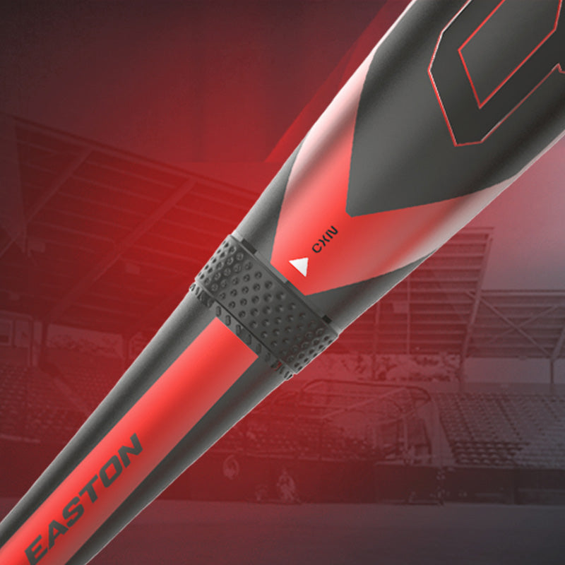 Close-up of a black and red Easton baseball bat, highlighting a textured grip area and a small white arrow labeled CINN, with a blurred stadium background.