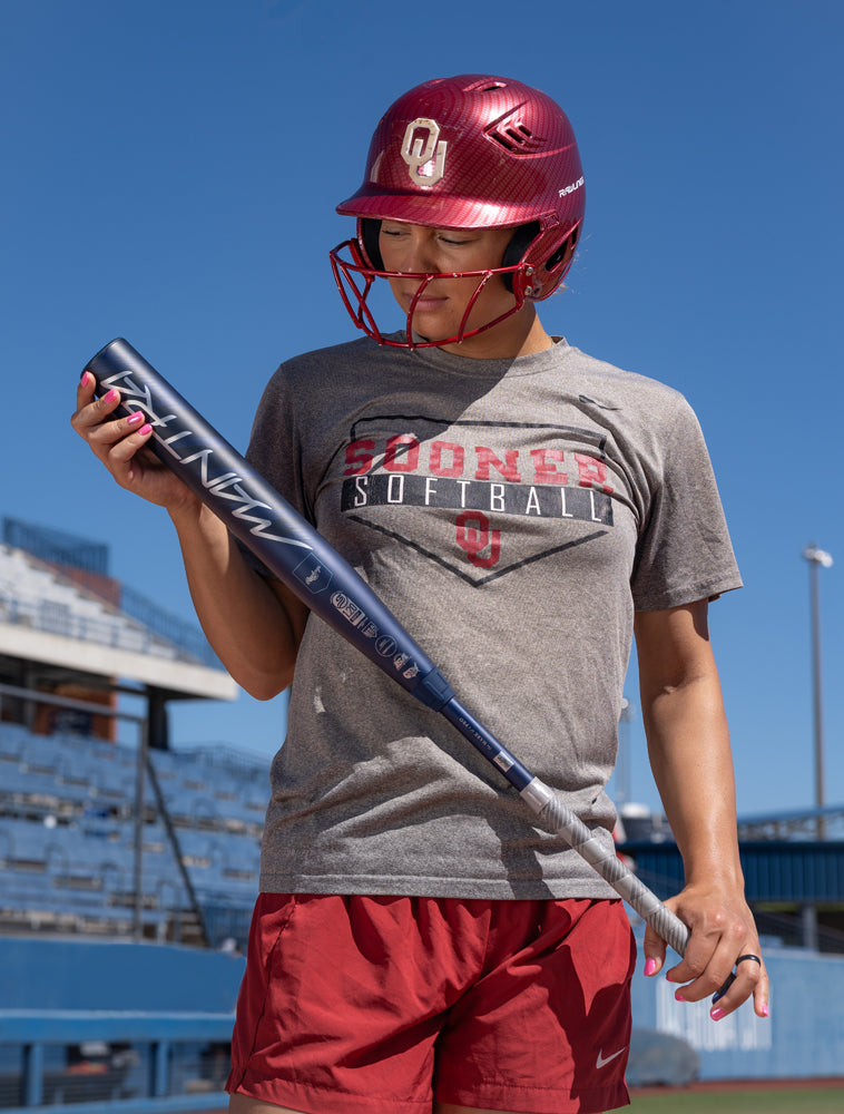 A player grips the 2025 Rawlings Mantra (-10) Fastpitch Softball Bat: RFP4M10 (DEMO) by Rawlings, ready to step up to the plate.