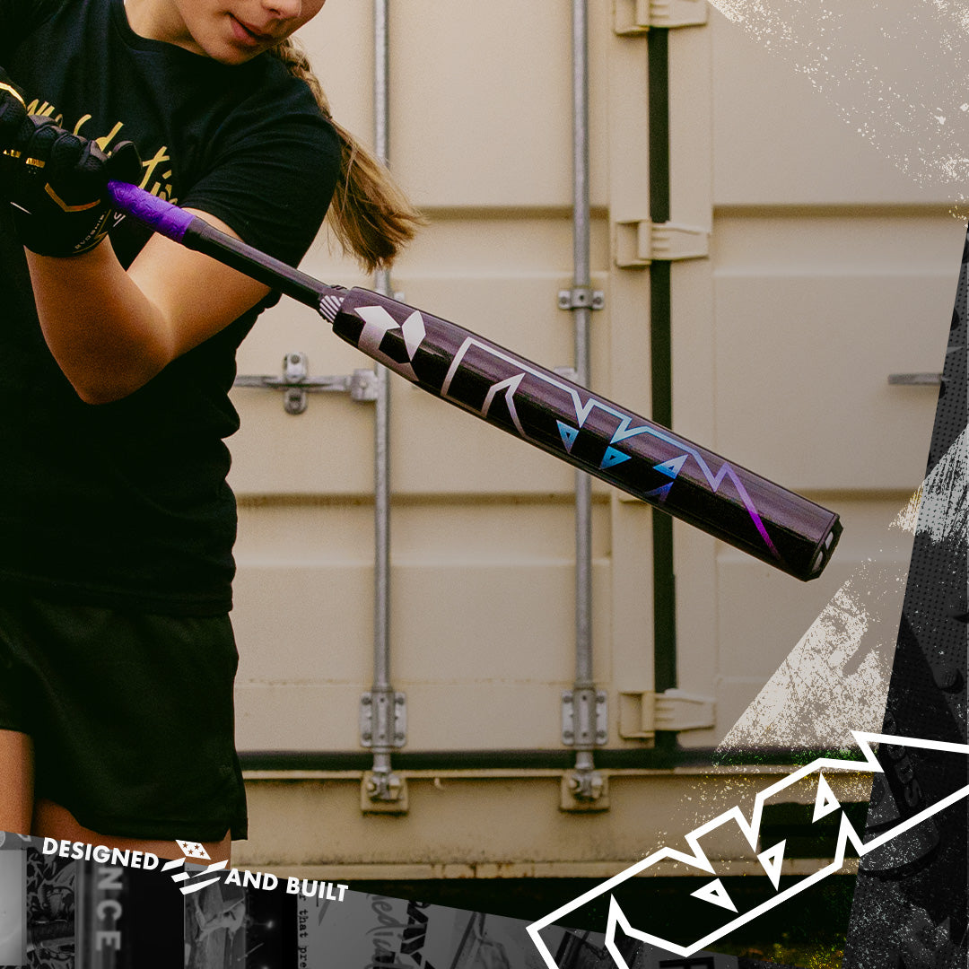 Wearing black athletic gear, a person readies to swing a 2026 DeMarini Prism+ (-11) Fastpitch Softball Bat (WBD2636010), featuring geometric designs, in front of a beige metal storage container.